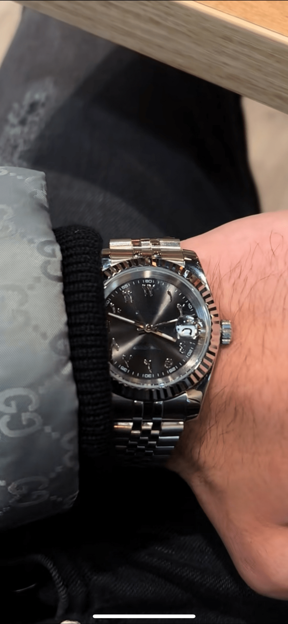 stainless steel Seiko NH35 mod with black Arabic dial, close-up on wrist