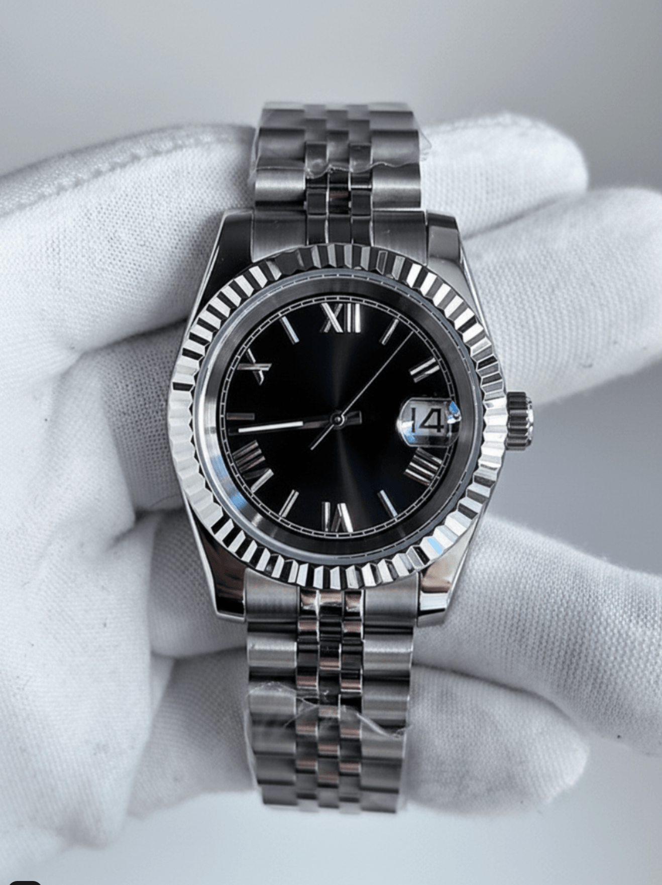 close-up of black Roman dial stainless steel Seiko NH35 mod watch in white gloved hand