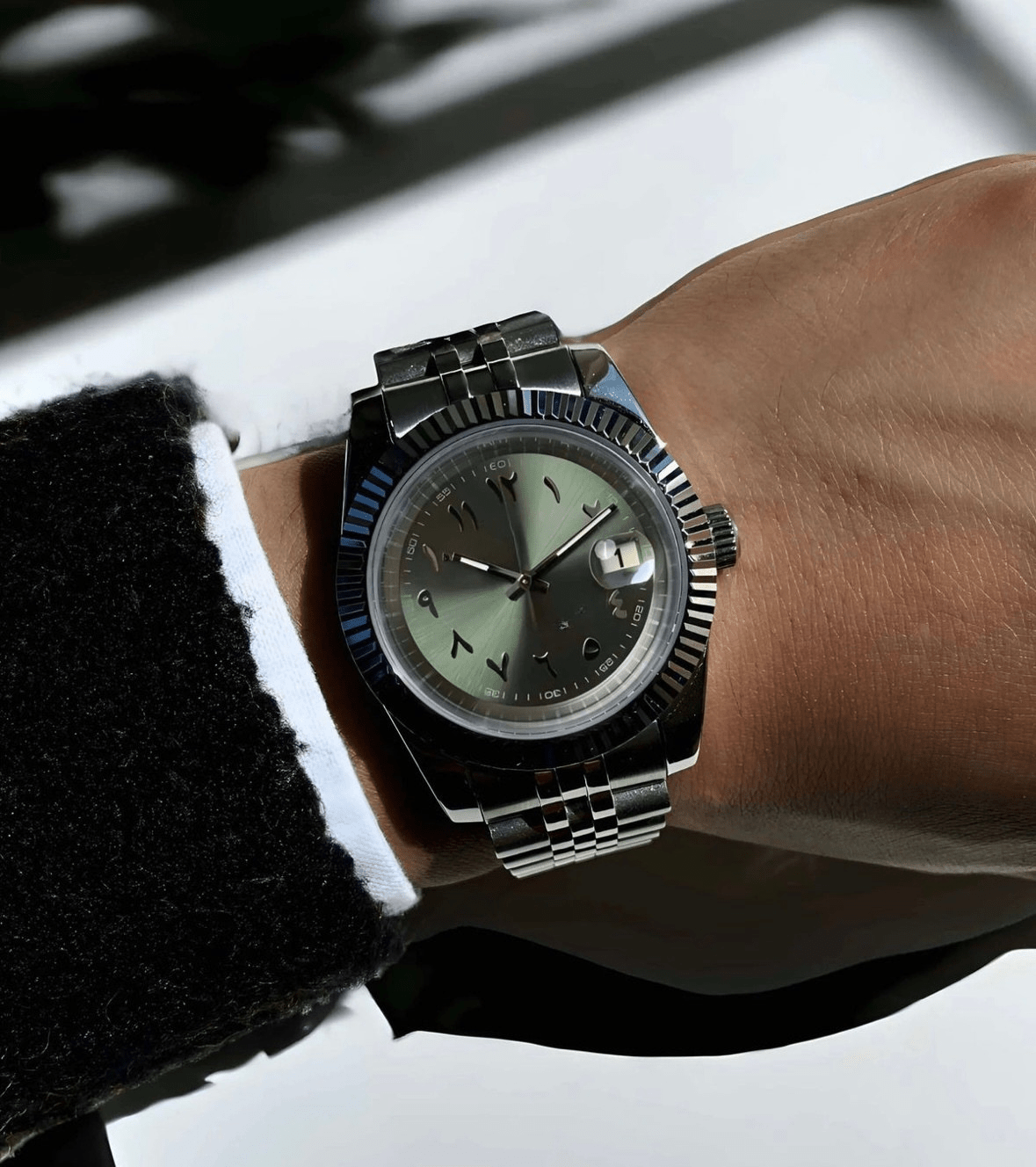 stainless steel Seiko NH35 mod with olive green Arabic dial, close-up on wrist