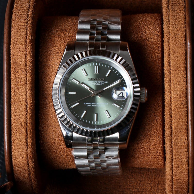 angled close-up of olive green sunburst dial Seiko mod watch showing date window and fluted bezel