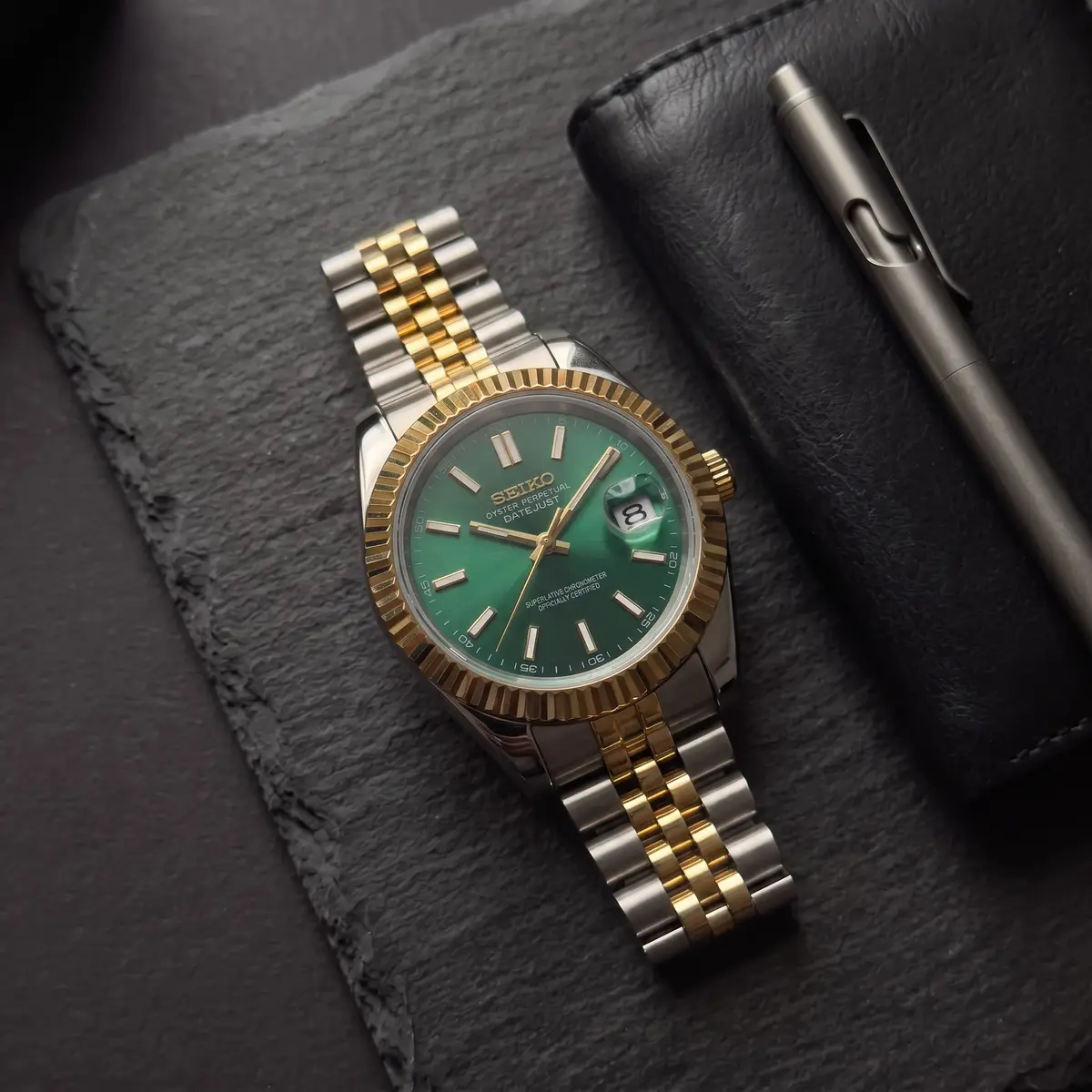 Seiko Mod Uhr CLASSIC MOD - SMARAGDGRÜN MIT GOLDLÜNETTE – Flatlay auf Schiefer – MedoMods