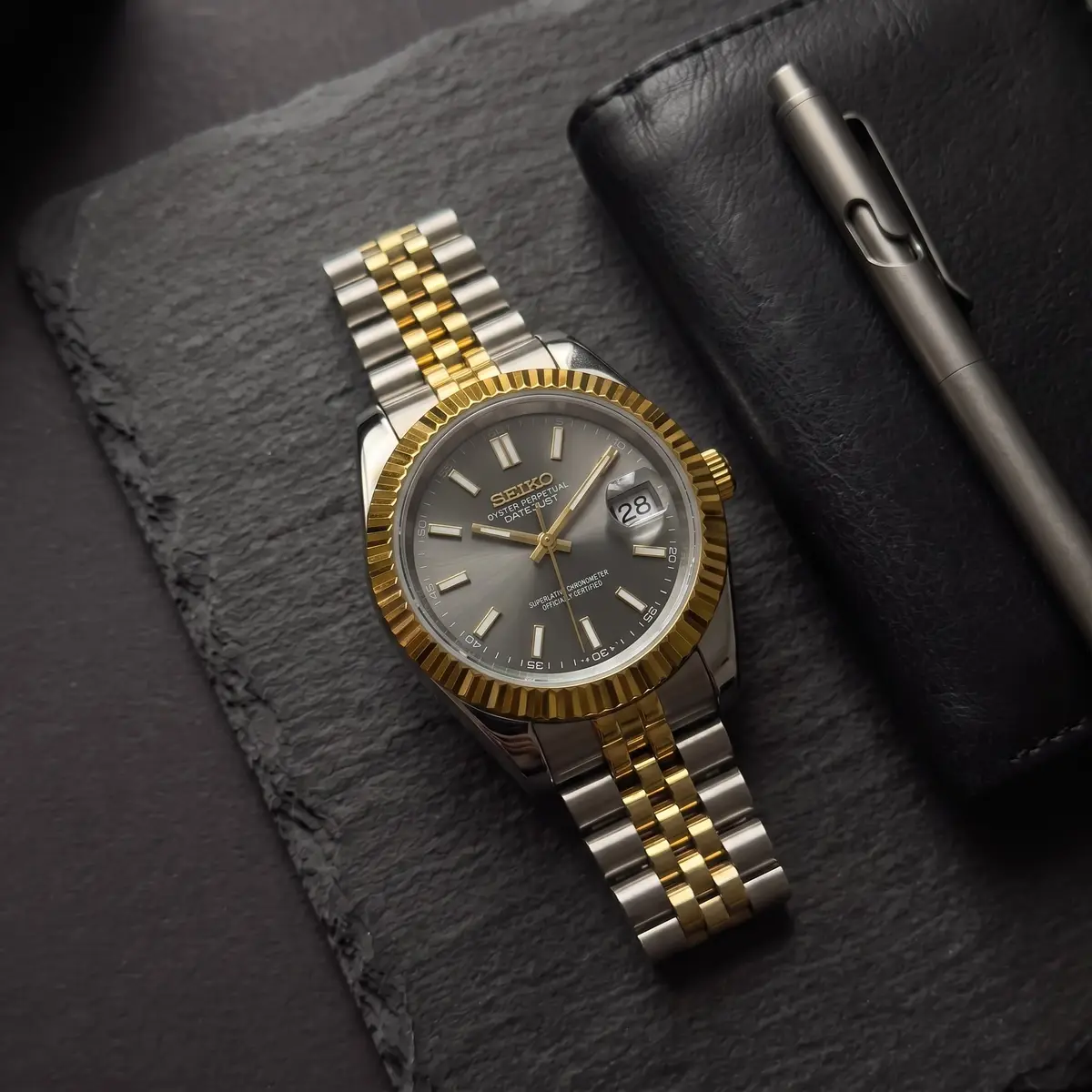 Seiko Mod Uhr CLASSIC MOD - ZWEIFARBIG GOLD & SCHWARZ – Flatlay auf Schiefer – MedoMods