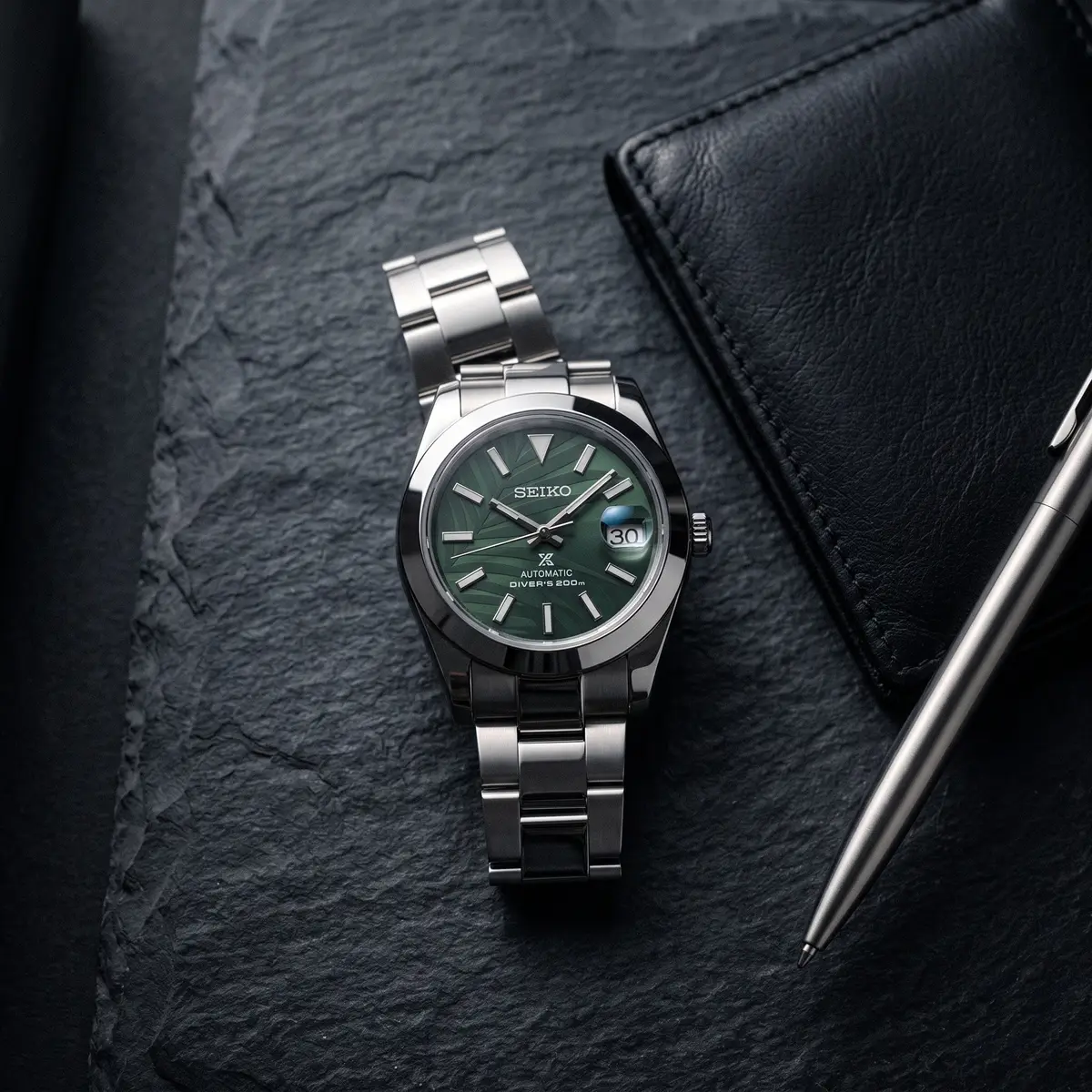 Seiko Mod Uhr DATE MOD | Stahl mit grünem Blattzifferblatt – Automatik – Flatlay auf Schiefer – MedoMods