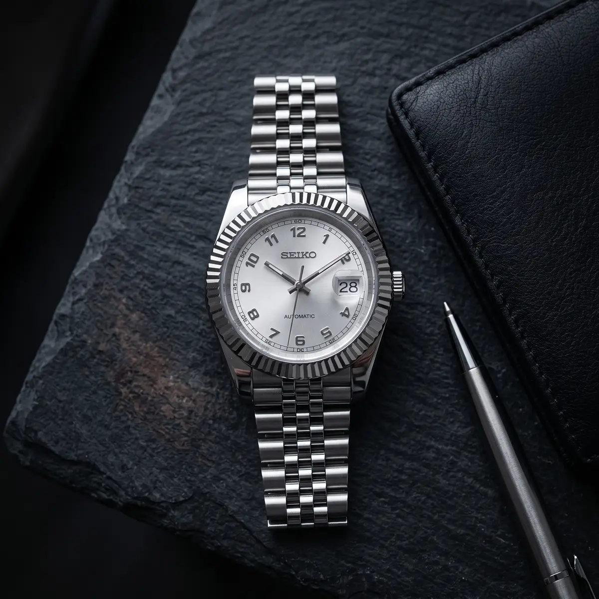 Seiko Mod Uhr DATE MOD | Zifferblatt aus Stahl mit weißer Struktur – Automatikwerk – Flatlay auf Schiefer – MedoMods