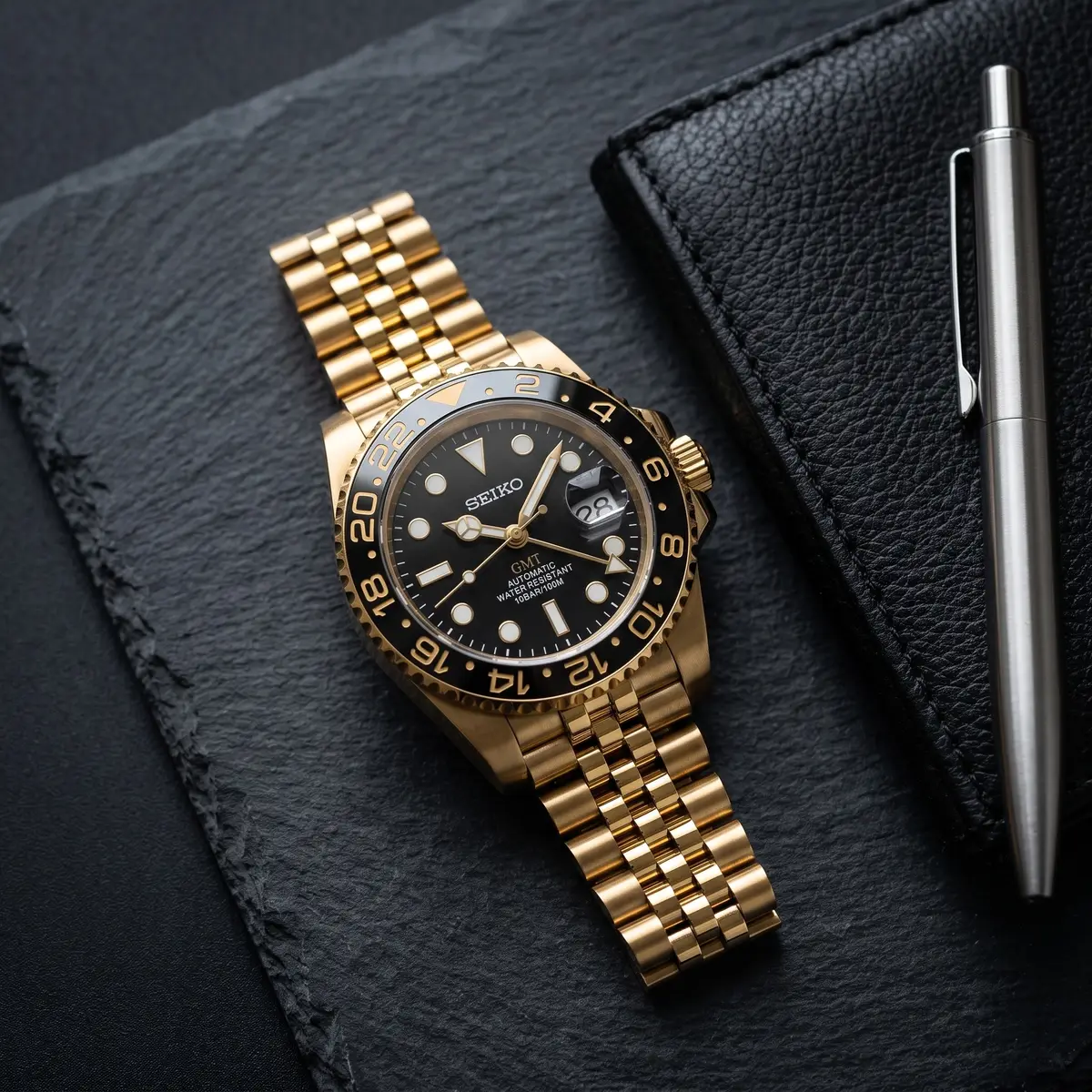 Seiko Mod Uhr GMT MOD – GOLD & SCHWARZ – Flatlay auf Schiefer – MedoMods