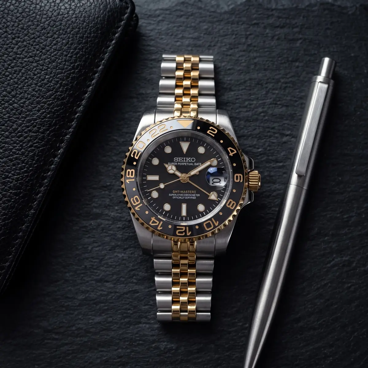 Seiko Mod Uhr GMT MOD | Zweifarbig Schwarz & Gold – Automatik – Flatlay auf Schiefer – MedoMods