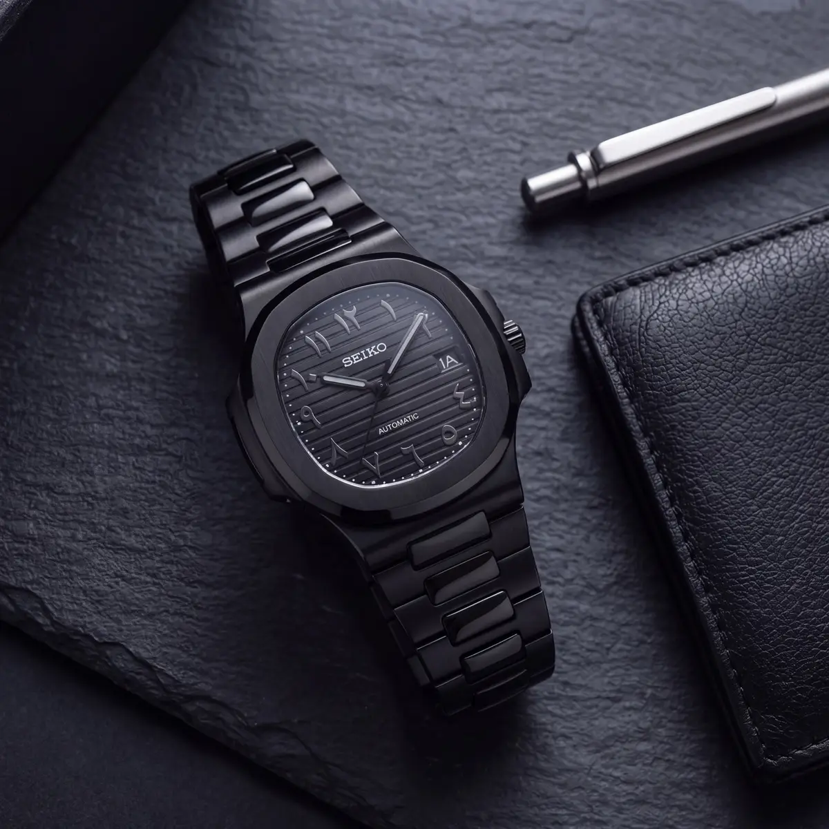NAUT MOD - STEALTH BLACK, NÚMEROS ARÁBIGOS – reloj sobre una superficie
