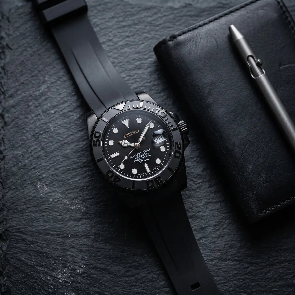 Seiko Mod Uhr Seikomariner | All Black PvD-Gehäuse – Kautschukarmband – Flatlay auf Schiefer – MedoMods