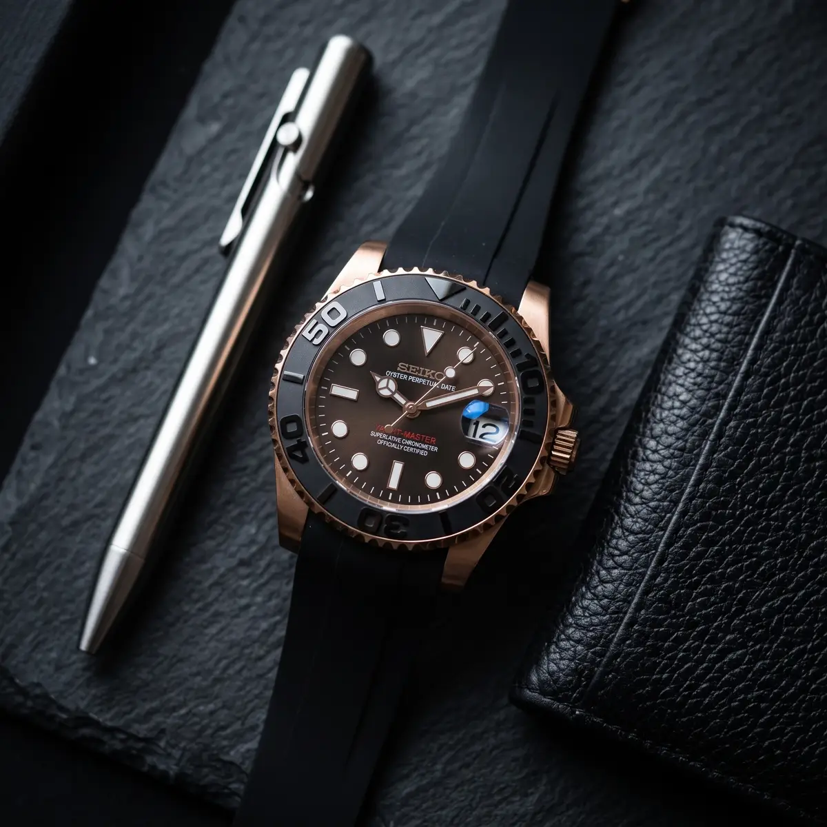 Seiko Mod Uhr Seikomariner | Schwarz & Roségold – Kautschukarmband – Flatlay auf Schiefer – MedoMods