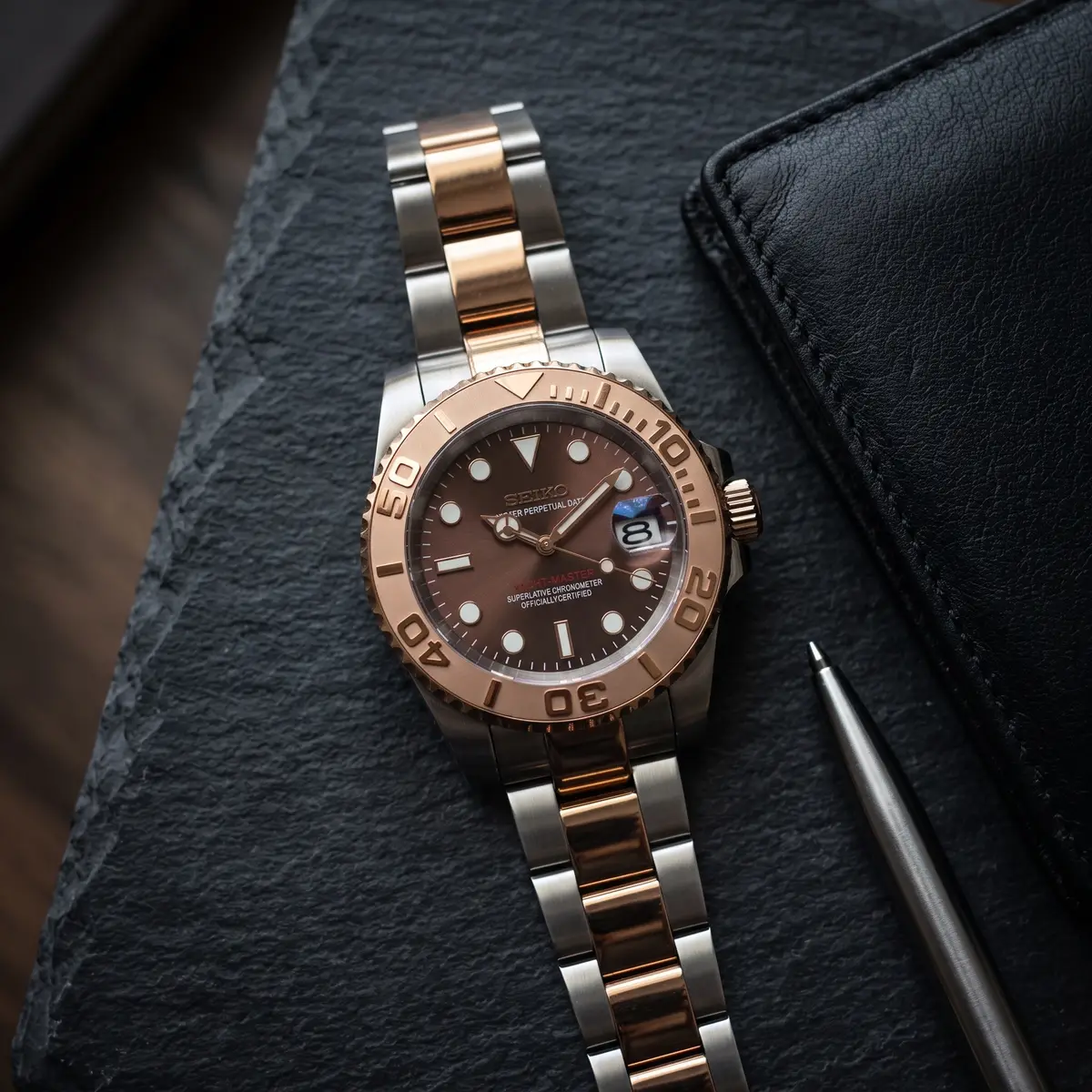 Seiko Mod Uhr Seikomariner Lünette in Braun/Schwarz – Flatlay auf Schiefer – MedoMods
