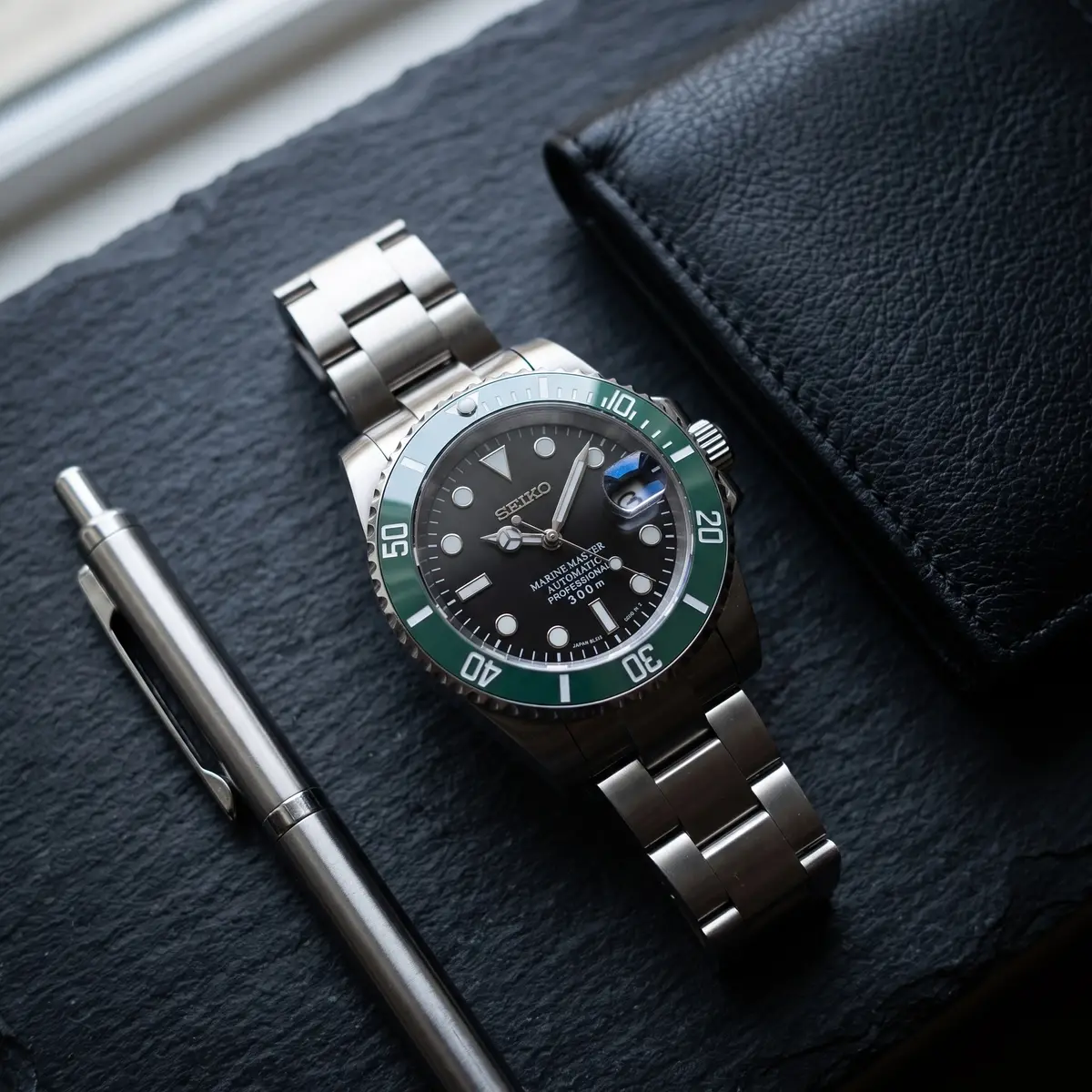 Seiko Mod Uhr Seikomariner | Grüne Lünette & schwarzes Zifferblatt – Flatlay auf Schiefer – MedoMods