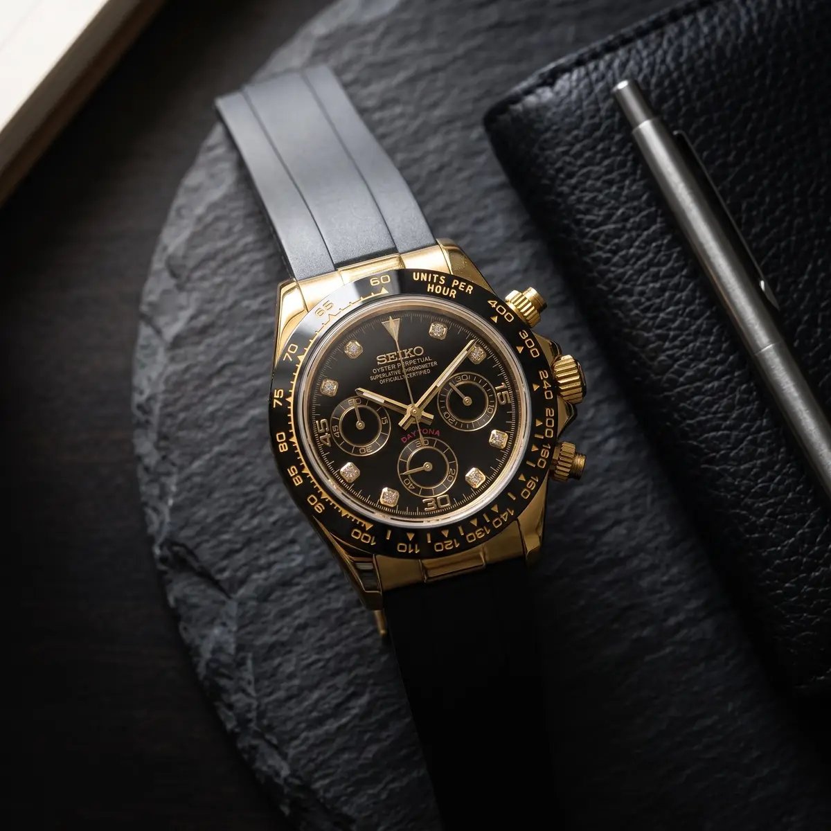 Seiko Mod Uhr TONA MOD | Schwarzes Kautschukarmband – Goldfarbene Rauten – 40 mm – Flatlay auf Schiefer – MedoMods